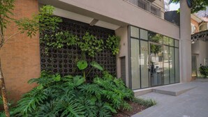 Un edificio moderno con fachada de ladrillo, entrada de vidrio y pared verde con plantas.