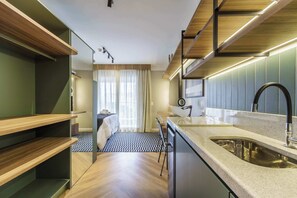 Een moderne keuken met inbouwapparatuur, een ruime gootsteen en een eethoek met een geruit kleed.