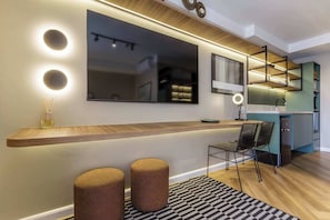 Een moderne keuken met een houten aanrecht, een inbouwspoelbak en een bar met krukken.