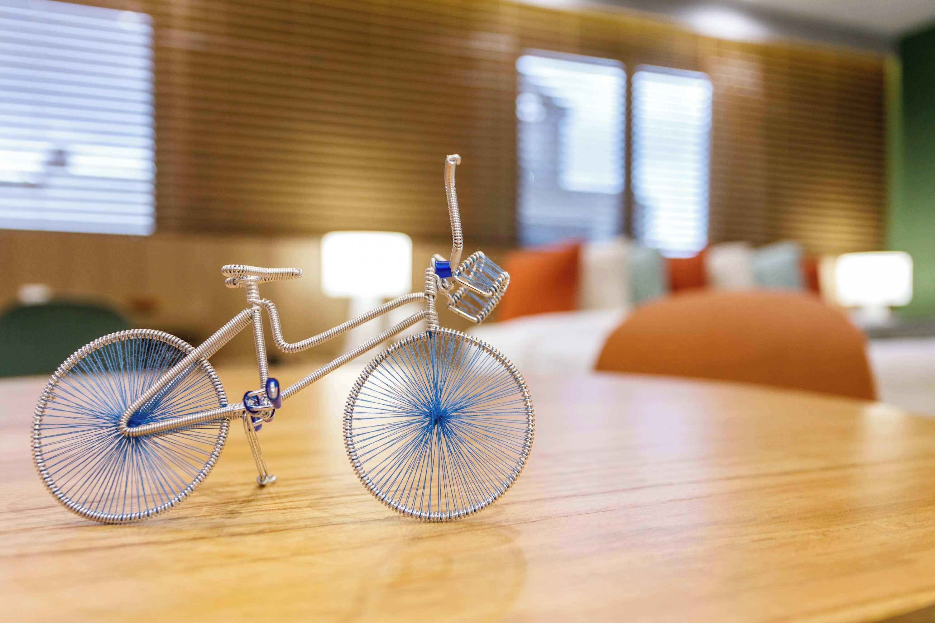 A bicycle with a basket and a small seat on a wooden surface.