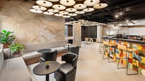 Un interno moderno con zona bar, posti a sedere e un design geometrico delle pareti.