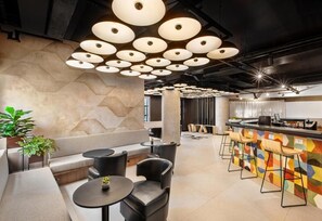 A modern interior with a bar area, seating, and a geometric wall design. - #IN608 | Cyclinn Jesuíno Arruda Itaim (Itaim Bibi)