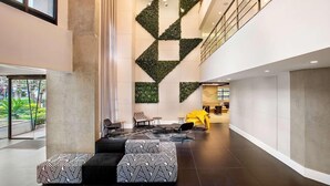 Spaziosa hall con un design geometrico della parete, area salotto e una reception ben visibile.