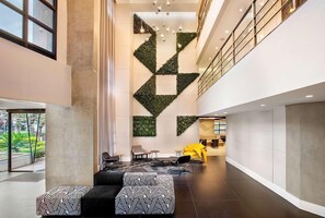 A spacious lobby with a geometric wall design, seating area, and a visible reception desk. - #IN608 | Cyclinn Jesuíno Arruda Itaim (Itaim Bibi)