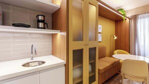 Eine moderne Küche mit Spüle, Kaffeemaschine und integriertem Schrank.