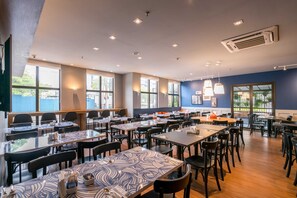 A spacious dining area with multiple tables and chairs, large windows, and ceiling lights. - #QL1304 | Cyclinn Faria Lima Pinheiros (Pinheiros)