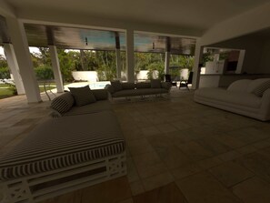 A covered outdoor seating area with striped sofas and a white sofa, a pool, and a kitchen area. - @Staycy | Casa próximo a Praia de Pernambuco! (Guarujá)