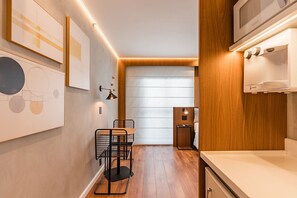 Eine moderne Küche mit Holzausstattung, einer Mikrowelle und einem Spülbecken.