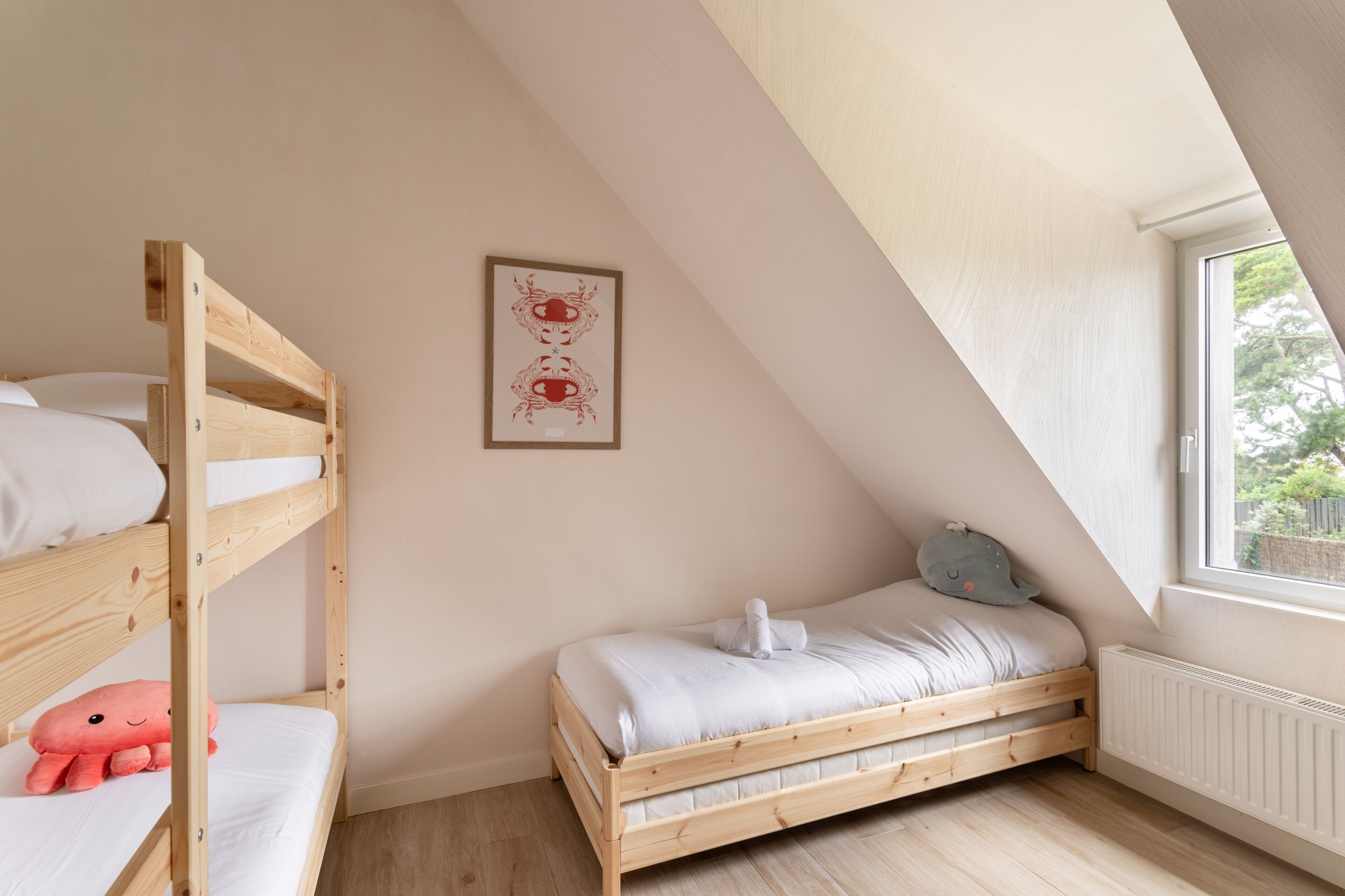 Ein Zimmer mit Etagenbett, einem Einzelbett, einem Heizkörper und einem Fenster mit Blick.