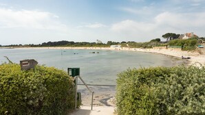 A coastal view with a sandy beach, a clear sky, and a pathway leading to the water. - Villa La Trinité Océan - Accès direct à la plage (La Trinite-sur-Mer)