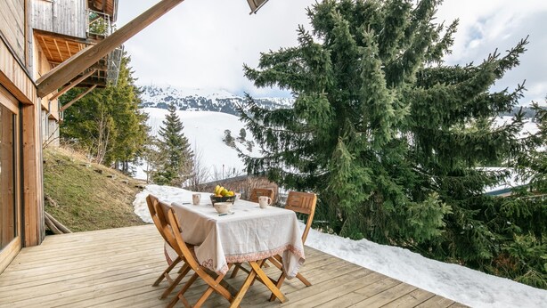 A wooden deck with a table set for dining, overlooking a snowy landscape and a lake. - Le Valhalla Chamrousse - Proche Télécabines (Chamrousse)