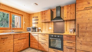 A wooden kitchen with a stove, oven, microwave, and wooden cabinets. - Le Valhalla Chamrousse - Proche Télécabines (Chamrousse)