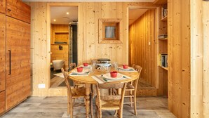 A wooden interior with a round dining table set for four, surrounded by wooden chairs. - Le Valhalla Chamrousse - Proche Télécabines (Chamrousse)
