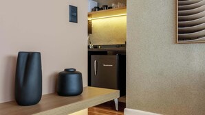 Eine moderne Küche mit integriertem Kühlschrank, einer Holzarbeitsplatte und einer Wandleuchte.