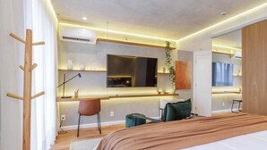Ein modernes Hotelzimmer mit einem Bett, einem Schreibtisch, einem Stuhl und einem großen Spiegel.