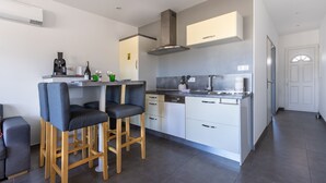 Una cocina moderna con una isla central, taburetes de bar y un comedor.