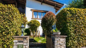 A stone house with a number plaque, a wooden staircase, and a well-maintained garden. - Relaxing break on the sunny slope with garden (Westendorf)