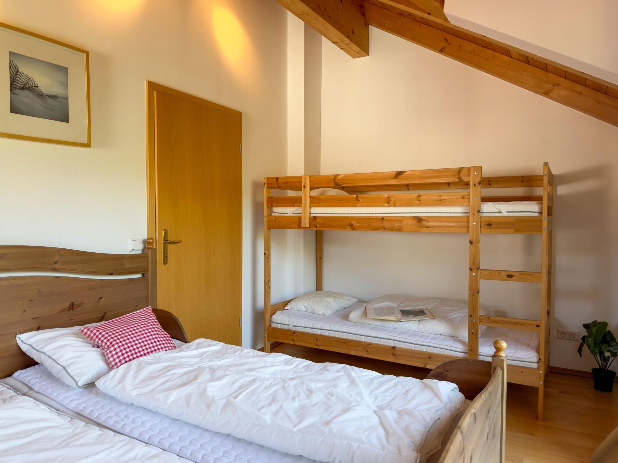 Una habitación con literas, una cama individual y techo de madera.