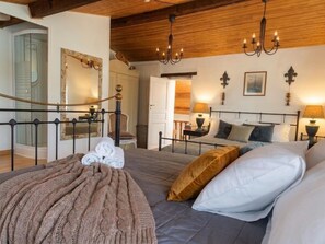 A bedroom with a bed, a bedside table, a lamp, and a mirror. - Authentic Charente house in a quiet natural area (La Villedieu)