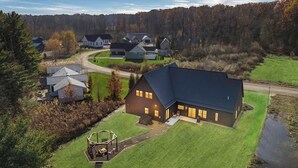 A residential area with houses, a large house with a dark roof, and a swing set in the yard. - Juniper Presents: NEW Luxe Stay w Hot Tub, Fire Pavilion Nr Lake MI (Berrien County)