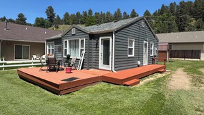 En bostadsfastighet med en veranda, en uteplats och en inhägnad trädgård.