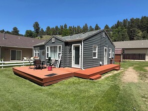 Ein Wohnhaus mit Terrasse, Patio und umzäuntem Garten.