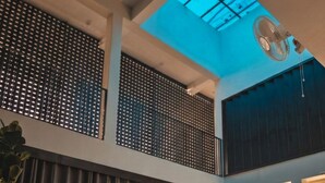 Un vaste espace de vie doté d’un haut plafond, d’une lucarne et d’un grand ventilateur.
