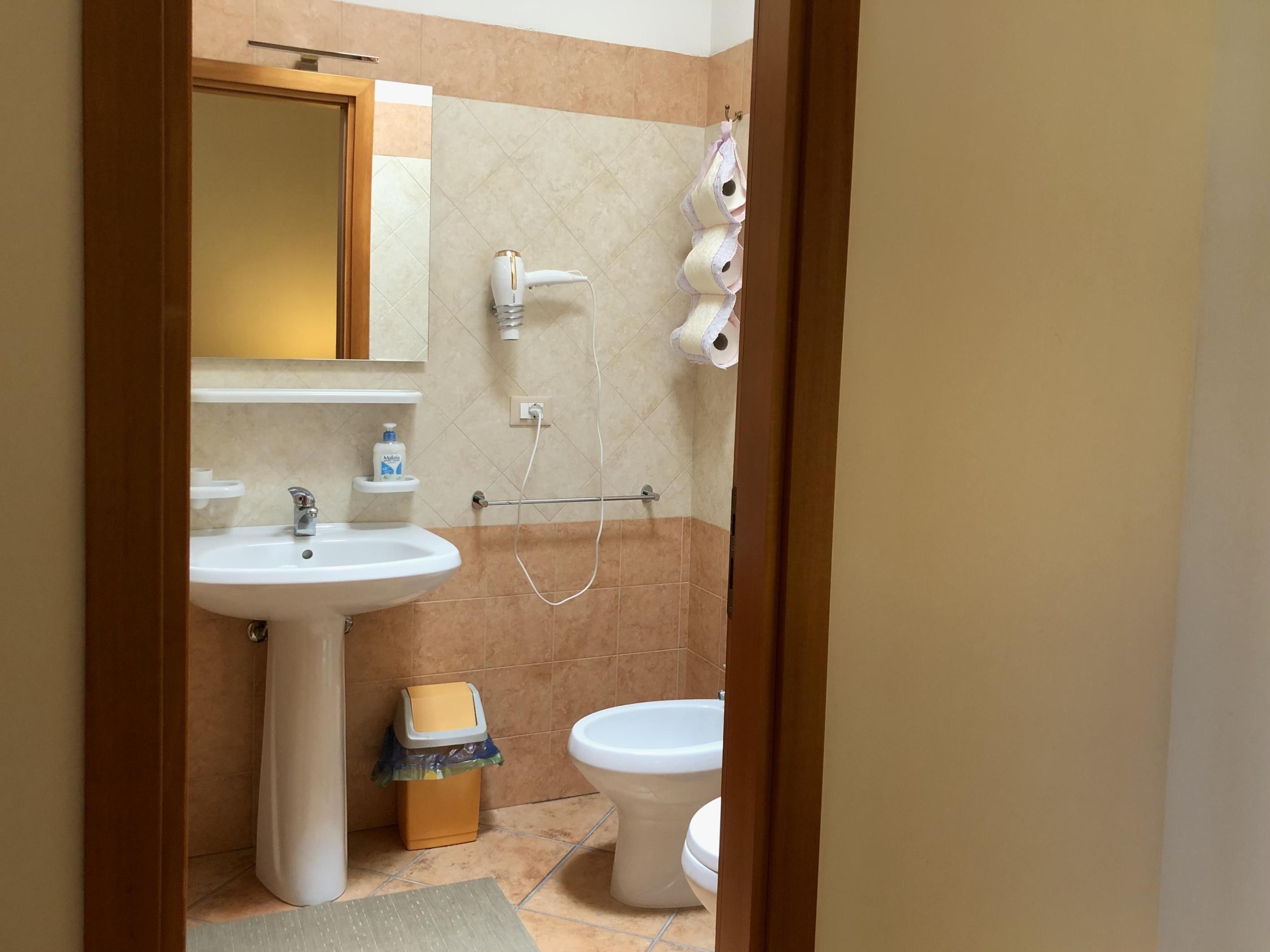 Une salle de bain équipée d’un lavabo, de toilettes et d’un porte-serviettes.