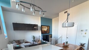 Eine moderne Küche mit weißer Arbeitsplatte, grauen Schränken und einem Holztisch.