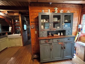 Eine rustikale Küche mit Holzschränken, einem Spülbecken und einem Essbereich mit Holztisch und -stühlen.