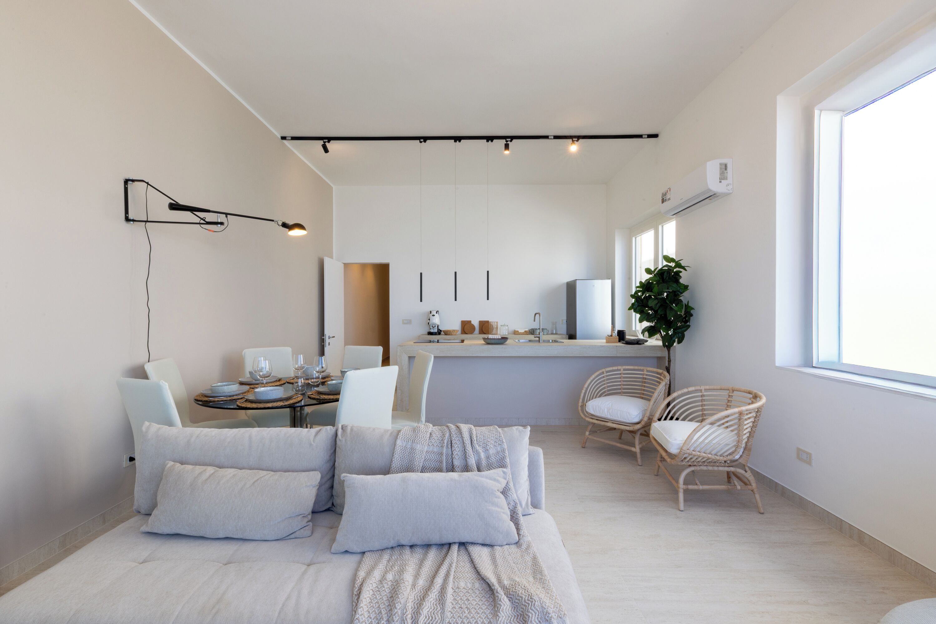 Ein modernes, helles Zimmer mit einem Bett, einem Essbereich und einer Küche.