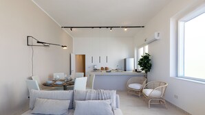 A modern, well-lit room with a bed, a dining area, and a kitchen. - Marzamemi on the beach SicilyMyHome (Marzamemi)