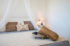 A bedroom with a bed, a bedside table with a lamp, and a bedside table with a cup. - Villa Alexandra SicilyMyHome (Santa Maria del Focallo)