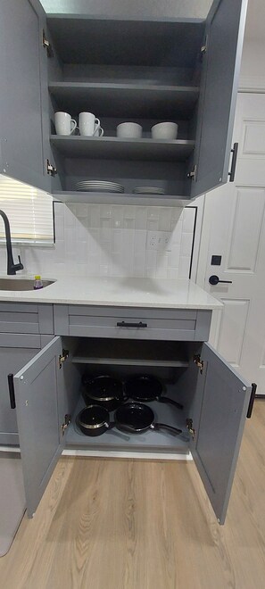 Eine Küche mit grauen Schränken, einer weißen Arbeitsplatte und einem eingebauten Backofen.