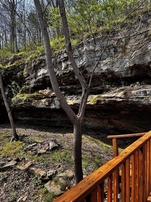 Eine Holzterrasse, die zu einer felsigen Klippe mit spärlicher Vegetation führt.