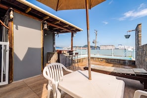 An outdoor patio area with a table, chairs, and a pool.