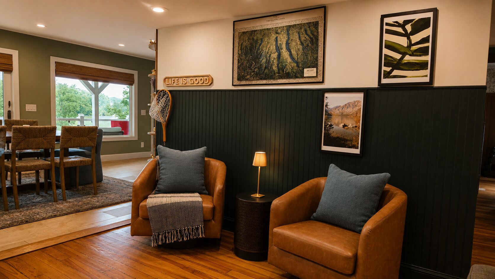 A living room with two leather armchairs, a coffee table, and a wall-mounted lamp.