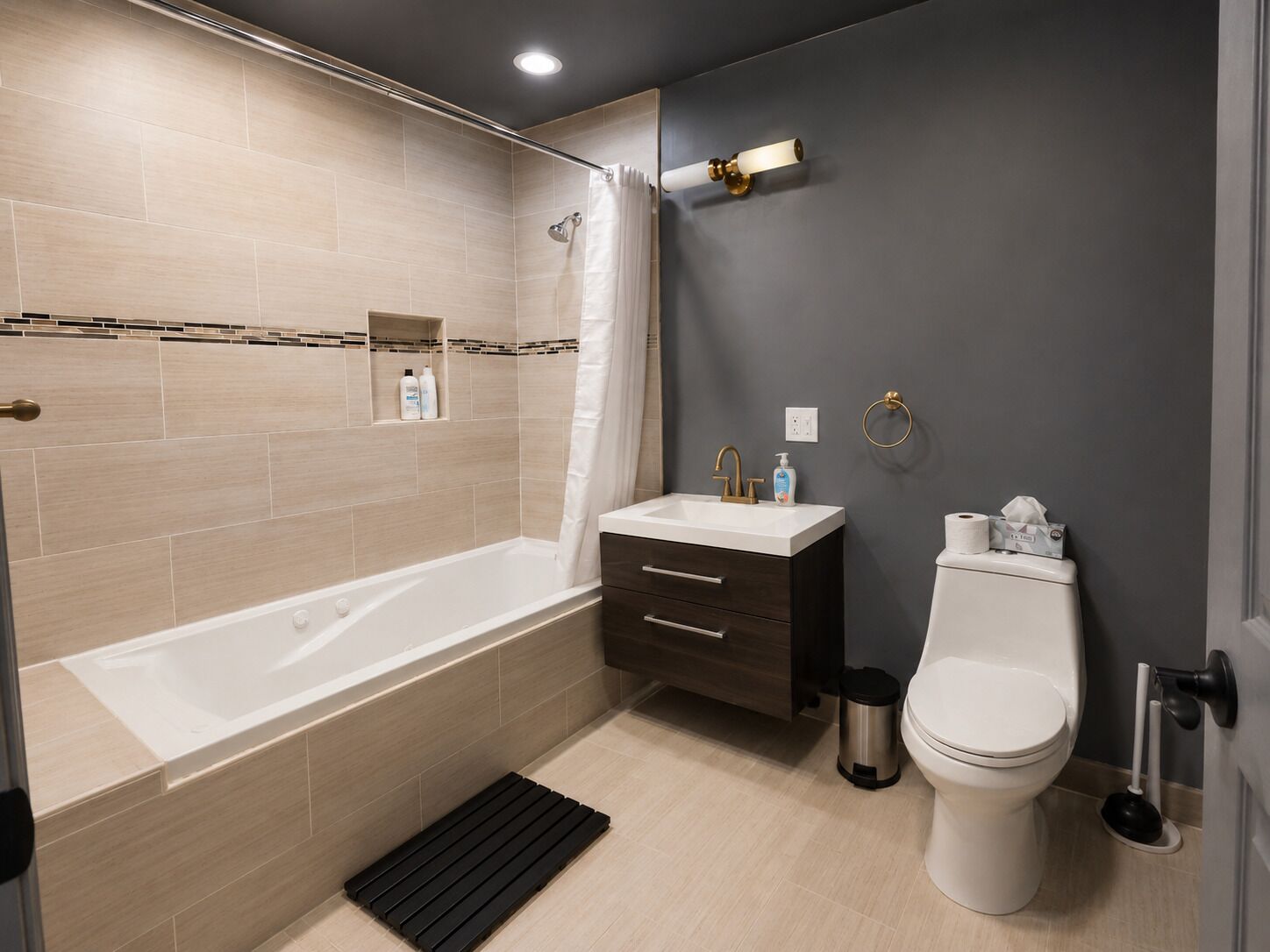 Un baño moderno con bañera, tocador, inodoro y cortina de ducha.