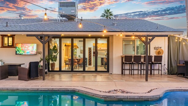 A house with a swimming pool, a dining area, and a kitchen.