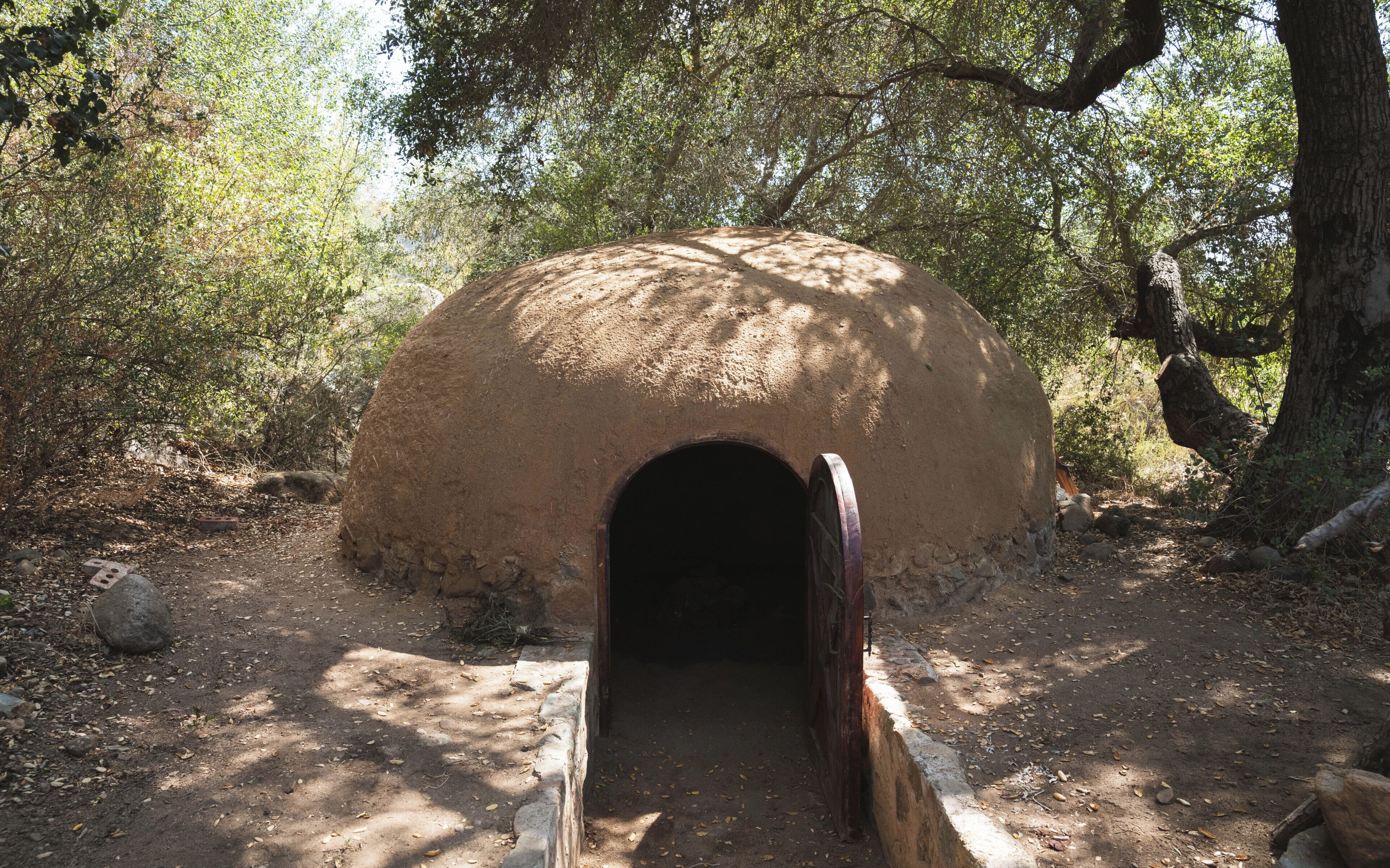 A traditional earth hut with a circular shape and a central entrance.