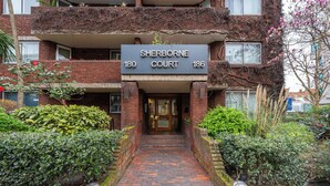 Un edificio con un cartel que dice 'Sherborne Court 180 186' en la entrada.