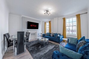 A modern living room with a sofa, coffee table, and TV. - Luxurious Two Bedroom Two Bathroom (London)