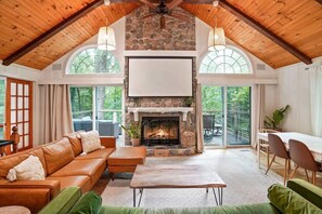 A cozy interior with a stone fireplace, leather sofa, and a dining area.
