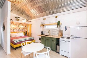Una cucina compatta con un fornello, lavello e pensili verdi.