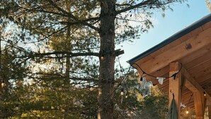 Un bain à remous installé dans un cadre extérieur enneigé, avec une terrasse en bois et un espace abrité.