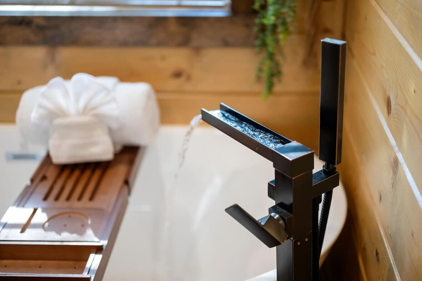 L’intérieur d’un chalet en bois, avec une baignoire, une serviette et un banc en bois.