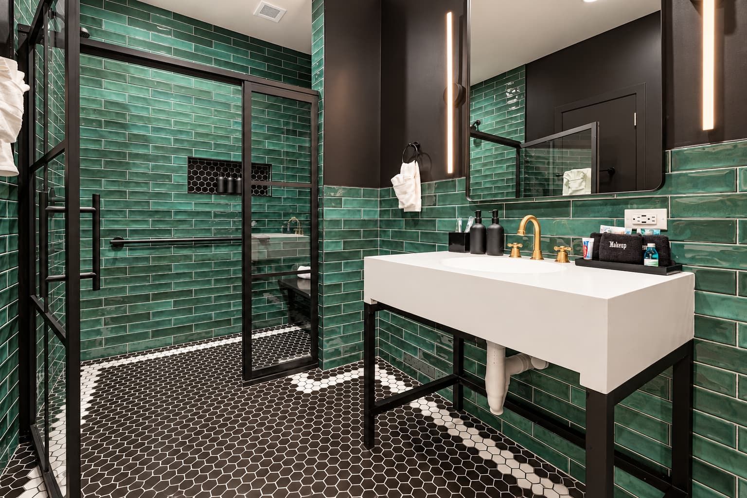 Une salle de bain moderne avec une douche à parois de verre, un lavabo blanc et un miroir au-dessus.