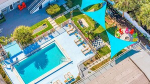 A rooftop pool with sun loungers, a small garden, and a building in the background. - Hawksbill 105 | Beach & Pool Studio | Walkable (Lauderdale-by-the-Sea)