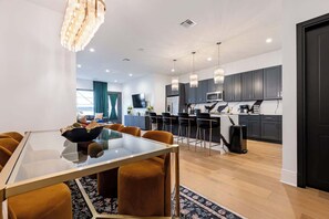 A modern kitchen with dark cabinets, a microwave, and a coffee machine.