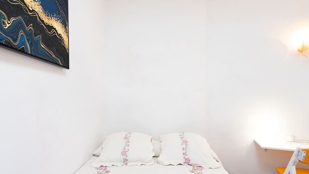 A bedroom with a bed, pillows, a desk, and a chair. - Apartamento Vistas Al Mar y Al Teide (Tacoronte)